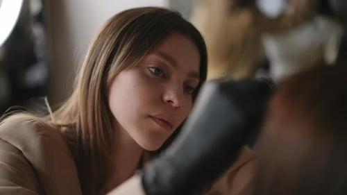 Focused Woman Applying Makeup at Spa or Salon