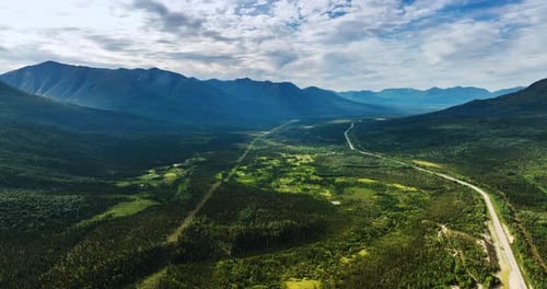 Spectacular vast valley among the stunning mountains. A road crosses the landscape.