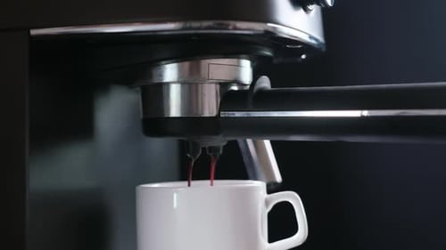 Home Espresso Making Process Coffee Stream Pouring From Machine Into Ceramic Cup