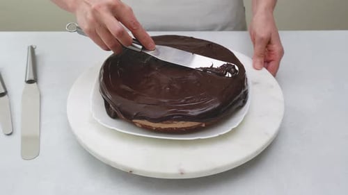 Rich Chocolate Frosting Spread on Delicious Layered Cake