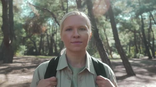 Eine hübsche Touristenfrau geht mit einer Aktentasche durch einen wunderschönen Wald