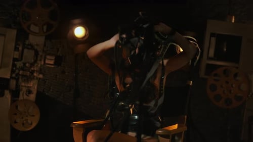 Closeup Shot of Woman in Black Dress Sitting on the Director's Chair Entangled in Film Strips Tries