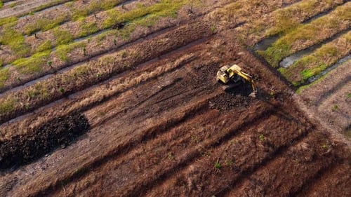 Aerial view of a wheel loader excavator with a backhoe loading sand into a heavy earthmover