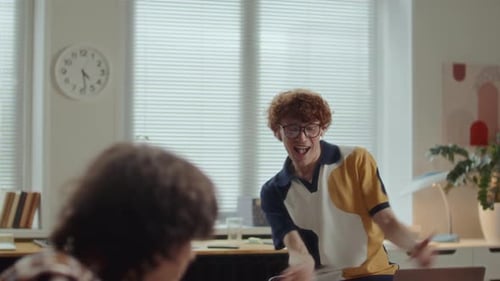 Excited Man Dancing and Celebrating Achievement with Team Support in Office