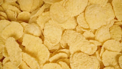 Background of golden corn flakes for a nutritious breakfast. Top view. Dolly slider, close up.