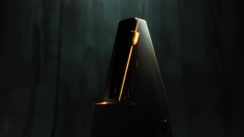 Dunkles Ambiente mit Licht über dem goldenen Metronom