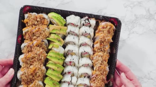 Flat Lay Prepackaged Variety of Sushi and Sushi Rolls in a Plastic Tray
