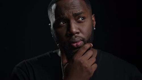 Thoughtful Man with Idea Gesture on Black Background