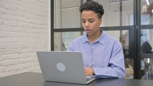 Woman Coughing While Working on Laptop at Office