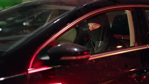 Masked Figure in Black Car at Night