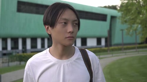 Attractive Asian Male Student on the Background of a College School or University