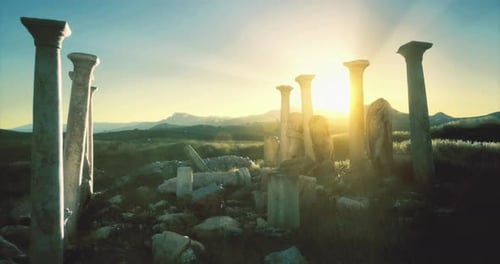 Ruins of Ancient Columns Basking in the Sunlight at Dusk in a Remote Landscape