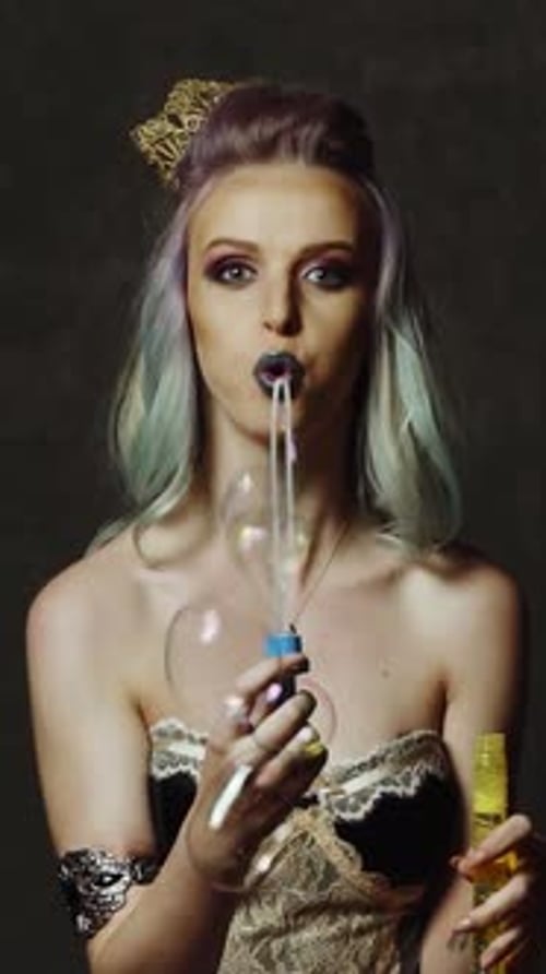 Woman with bubble. Young girl having fun with bubbles in studio