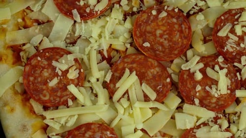 Rotating top down shot of an uncooked pizza. One side of the crust just in view.