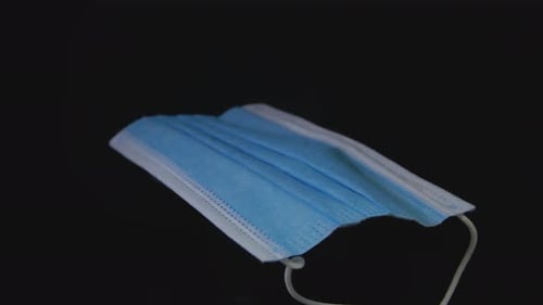 Close Up of Blue Surgical Mask on Black Background