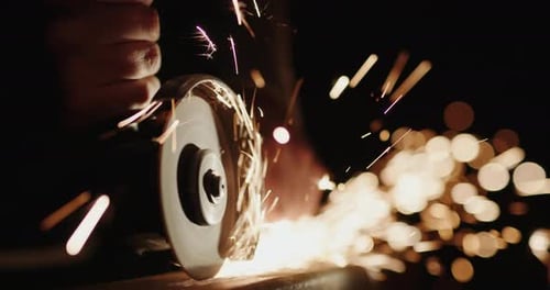Un soldador limpia las costuras del metal con herramientas eléctricas manuales Vídeo en cámara lenta