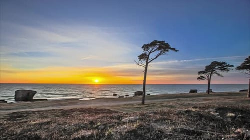 Day to night time lapse - moon follow sun's path after sunset over ocean
