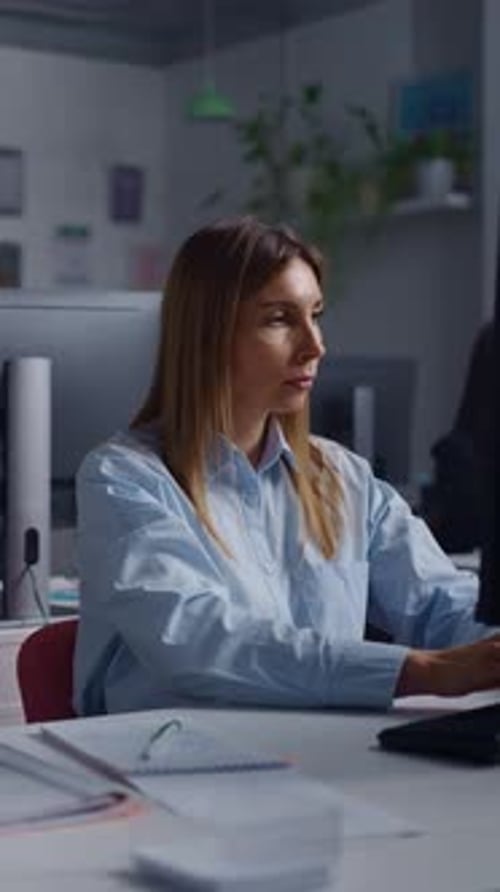 Focused Office Worker Typing on Computer at Modern Workstation Concentrating on Tasks While Sitting