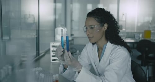 Woman Scientist Examining Test Tubes in Laboratory