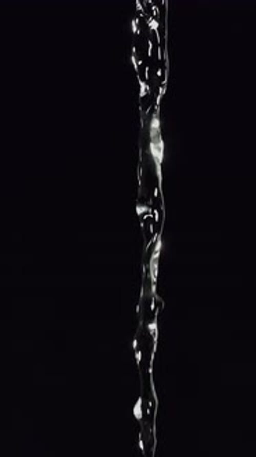 Fluxo gracioso de água limpa caindo em cascata por um pano de fundo escuro