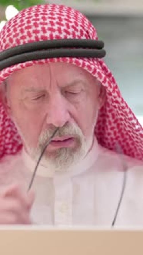 Senior Man Massages Temples, Looks Tired Working on Laptop