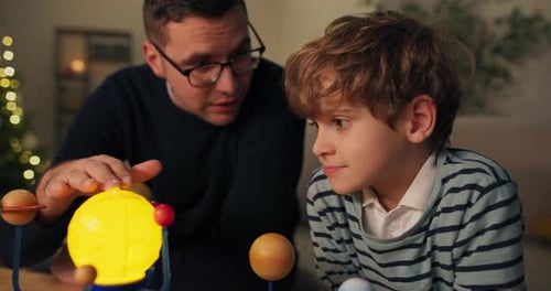 Father and Son Explore Solar System Model at Home