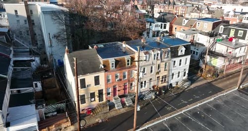 Vista aérea iluminada por el sol de casas adosadas y calles urbanas históricas
