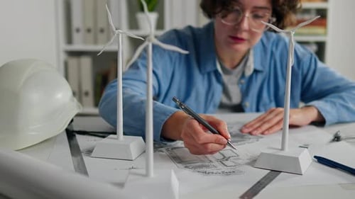 Engineer sketches wind turbine designs on a blueprint during a creative brainstorming session