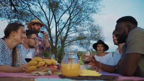 Friends Gather Around Picnic Table with Wine