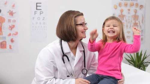 Pediatrician with Child in Doctor'S Office Bed