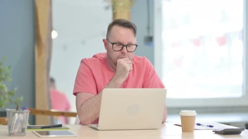 Adult Man Working on Laptop Coughing Indoors