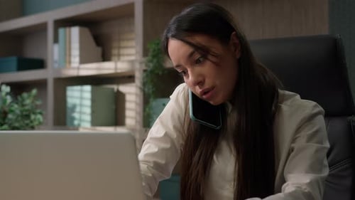 Caucasian Businesswoman Talking Phone Typing Laptop Multitask in Office Business Girl Woman Using