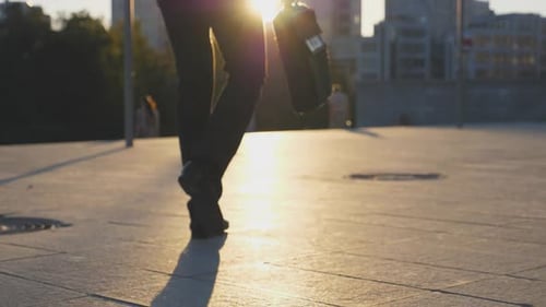 Feet of Businessman with Briefcase Walking in City Street at Sunset Time Businessman Commuting to