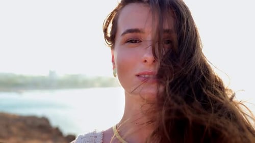 Portrait of Enchanting Cute Serious Young Caucasian Woman Looking at Camera on a Seaside Beach