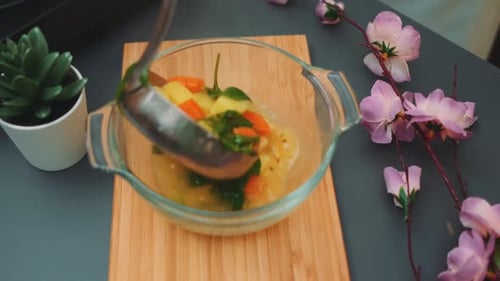 Pouring Soup Into a Glass Bowl