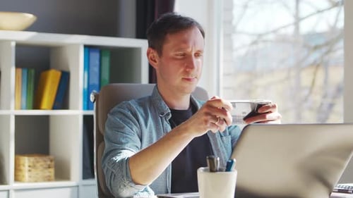 Young Male Entrepreneur Works at Home Office at the Computer Workplace of Freelancer or Student