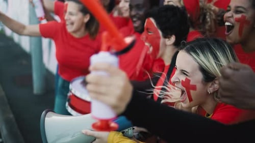 Sports Fans Cheering with Red Face Paint and Enthusiasm
