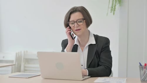 Business Woman Works on Laptop and Talks on Phone
