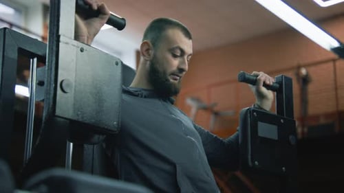 Bearded Man Working Out on Weight Machine in Gym