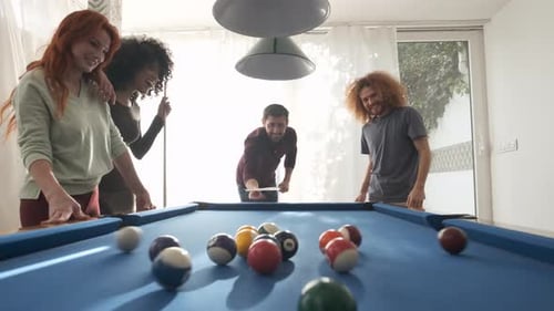 Man Playing Pool with Diverse Friends in Game Room on Weekend