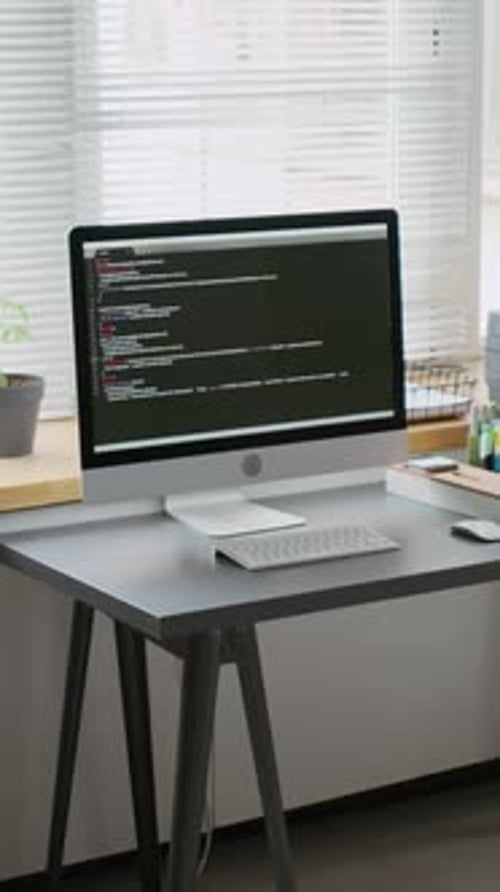 Computer Displaying Code on Desk in School Classroom