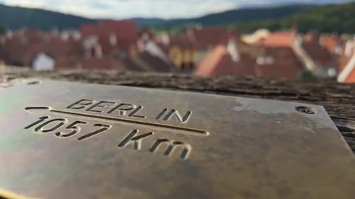 Close-up of a metal plate indicating the distance to Berlin from the Clock Tower in Sighișoara.