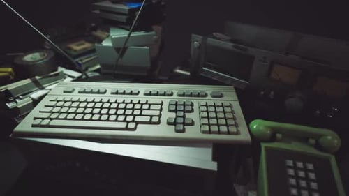 Vintage Keyboard and Retro Technology Arranged in a Cluttered Workspace