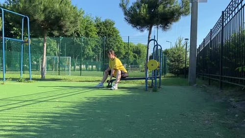 Young woman works out at the sport area outdoors