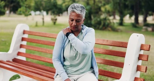 Woman Massaging Shoulder in Green Park