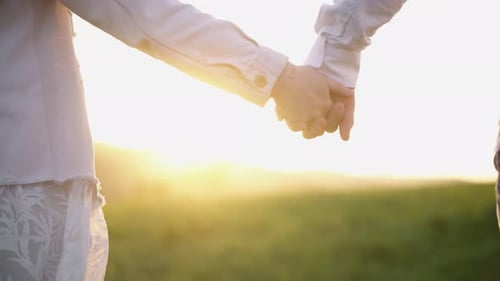 Couple Holding Hands in a Rural Field