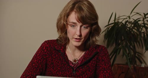 Woman Works at Computer in Indoor Setting