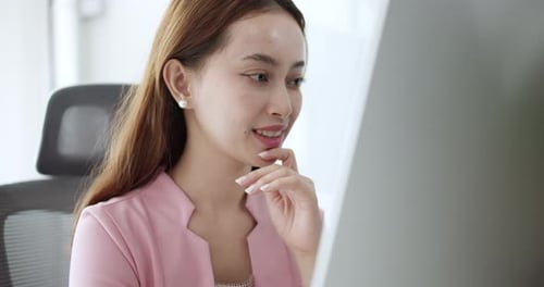 A dedicated professional engages with their computer immersed in tasks in a contemporary office sett