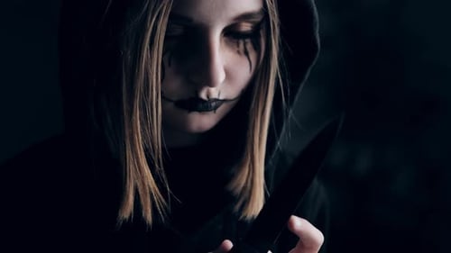 Girl with Dark Makeup Holding Knife Inside
