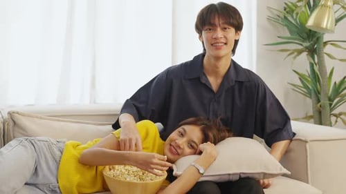 Smiling Couple Relaxing at Home with Popcorn